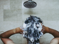 Person vasker hår i brusebad